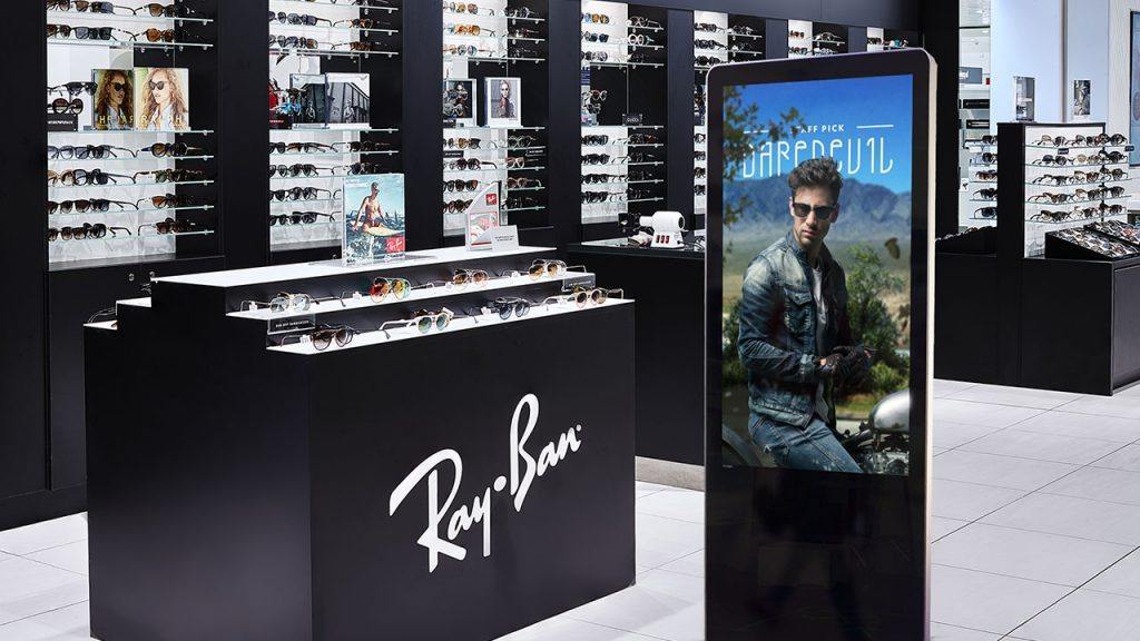 Digital signage kiosk display showing a branding design inside of a trendy eyewear store